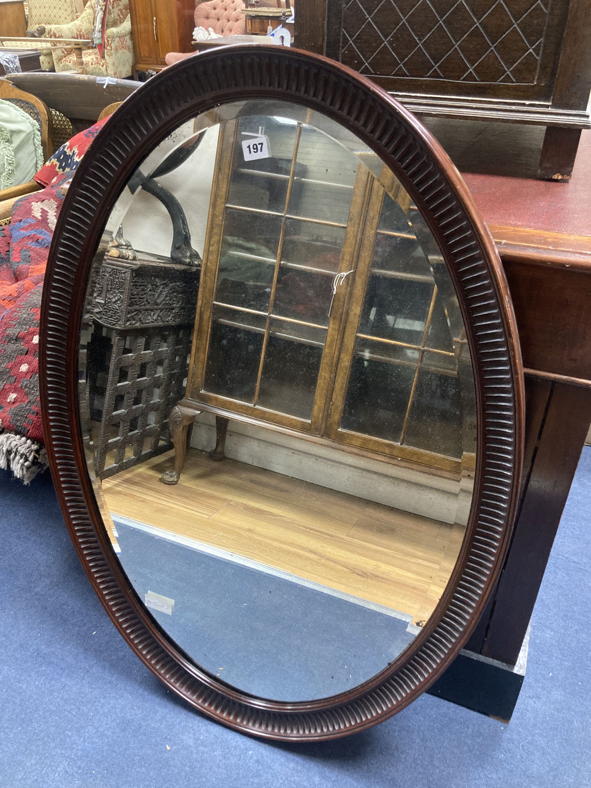 A 1920s oval-framed mahogany wall mirror, width 70cm, height 100cm
